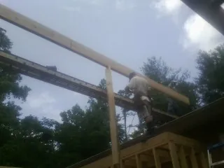 Carpenter setting a ridge beam over a new addition frame — Ice Dam Removal by Roofing Brothers in Gaithersburg