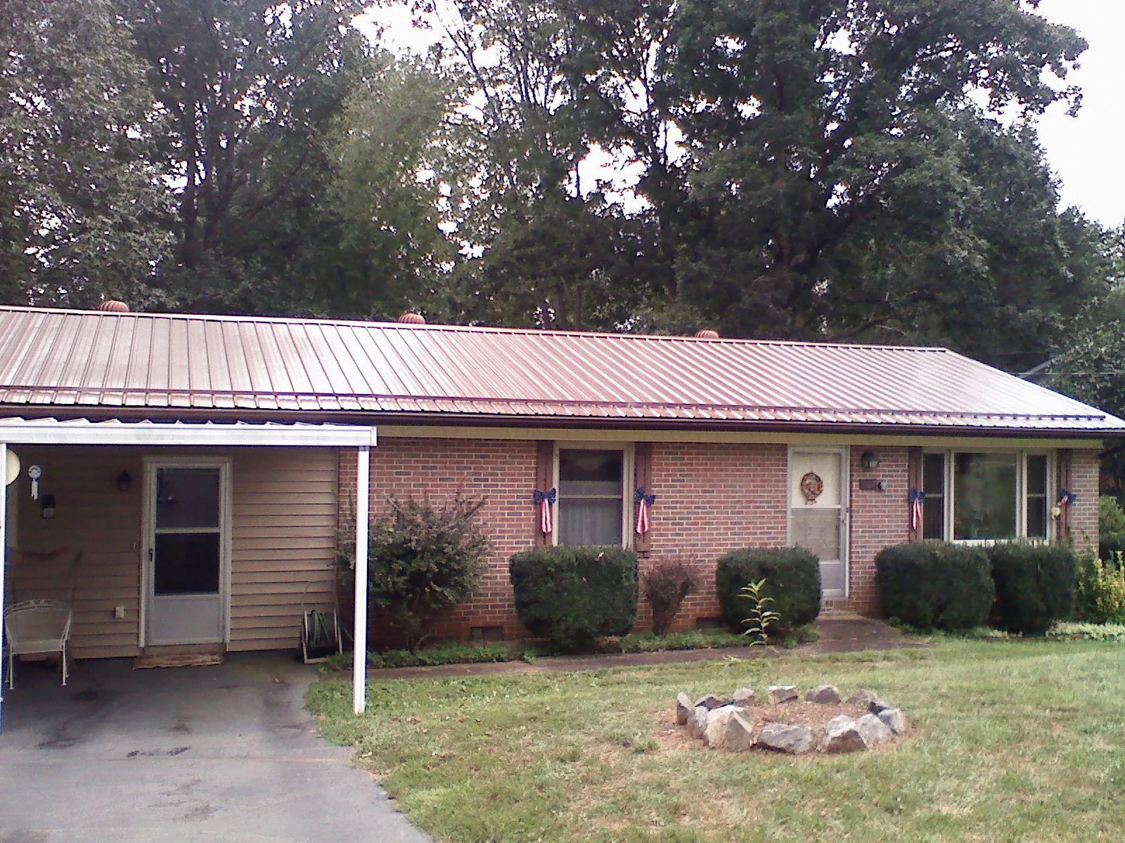 Bronze metal roof and carport on a brick ranch home — Roof Repair work by our crew in Gaithersburg